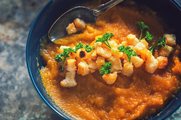 Close up of fresh homemade pumpkin soup served with croutons
