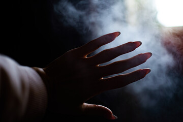 Fototapeta na wymiar hand on the background of smoke