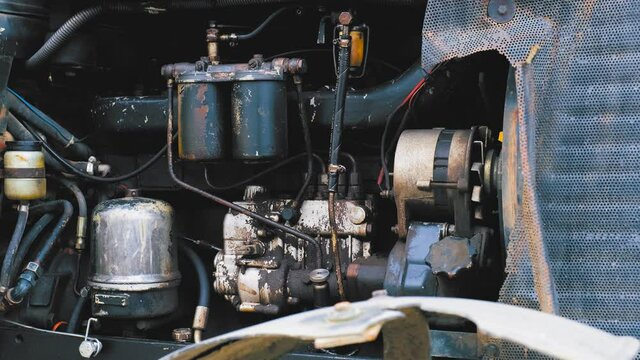 Exposed Dirty Tractor Engine under Opened Hood Mesh Closeup