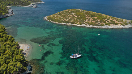 Aerial drone photo of famous bay and small traditional village of Atsitsa covered in pine trees and natural sandy beaches, Skiros island, Sporades, Greece