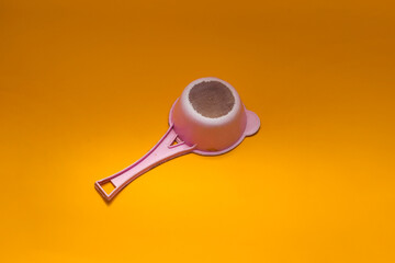 Old used pink plastic tea strainer (colander) isolated on orange background