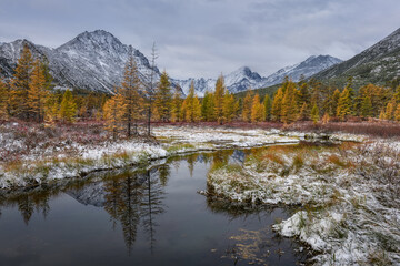 The first snow in the valley of the mountains on an autumn cloudy day