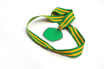 Graduation medal with the empty green pentagon-shaped medal and green-yellow stripes ribbon isolated on white background. Education, sport, champion, winners concept background stock images.