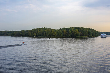 Scenic river landscape with green trees in early autumn