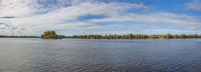 Scenic river landscape with green trees in early autumn