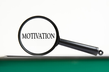 magnifying glass with text motivation on notebook
