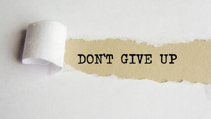 DONT GIVE UP. words. text on gray paper on torn paper background