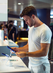 Young man buying gadget in store