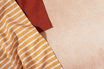 Stack of colored cloth serving napkins on beige plastered background