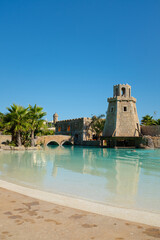 Quiet and empty swimming pool with a castle on a summer resort under a blue sunny summer sky