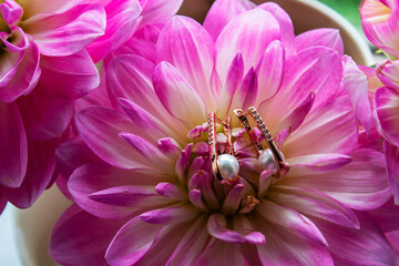Two pearl earrings are in flower bud peony