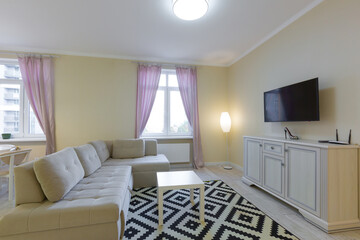 living room interior, with large sofa and TV, with purple curtains, modern style in light colors