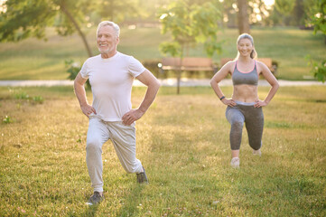 A mid aged couple having a workout in the park