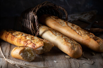 Baguettes with garlic in a wicker basket on a wooden table