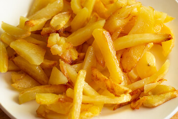 a plate of mouth-watering fresh fried potatoes with a golden crust