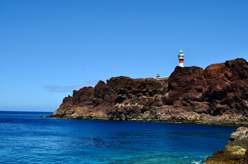 Faro en acantilado volcánico junto al mar