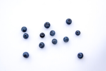 Flat lay composition with juicy, fresh blueberries. Isolated ecological ripe sweet bilberry fruits on white background. Copy Space. Top view of healthy organic summer vegetarian dessert food for diet