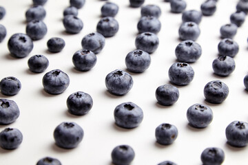 Blueberries with shadows on white table