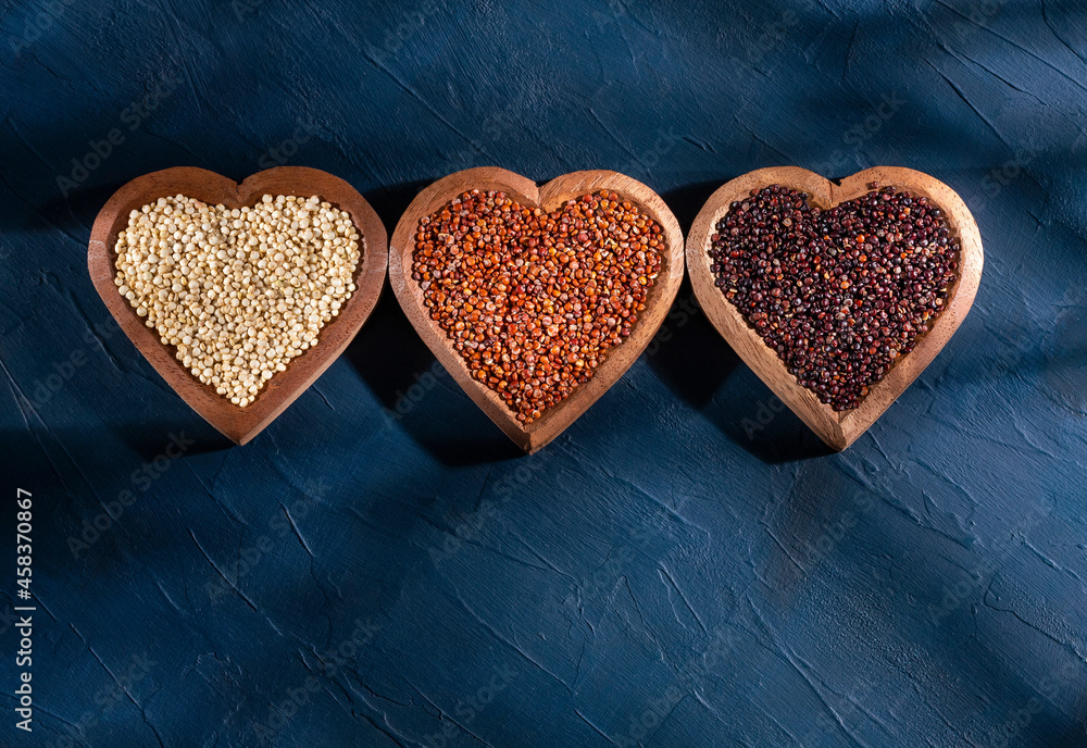 Wall mural Chenopodium quinoa - White, black and red quinoa seeds in the heart-shaped bowl