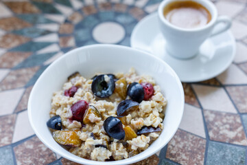 Breakfast background oatmeal with berries and coffee. Espresso with porridge for breakfast