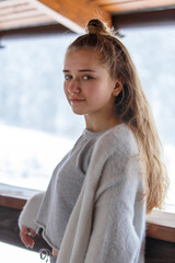 Portrait of young teenage girl in warm cozy clothes at the terrace