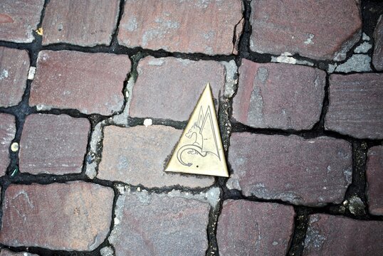Golden, triangular sign points the way to a dragon. In French folklore, the Graoully (Graouli, Graouilly, Graouille or Graully) is a dragon who lived lived in the Roman amphitheater in Metz, France. 