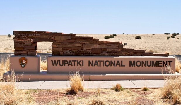 Wupatki National Monument, Arizona: Entrance sign with National Park Service arrowhead logo. Sign design mirrors the pueblo dwellings found at this archeological site near Flagstaff, Arizona.