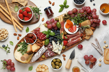 Set of different delicious appetizers served on white wooden table, flat lay