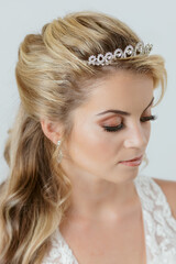blonde caucasian bride on white dress hairdressing detail