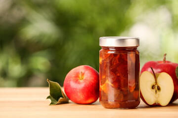Delicious apple jam and fresh fruits on wooden table. Space for text