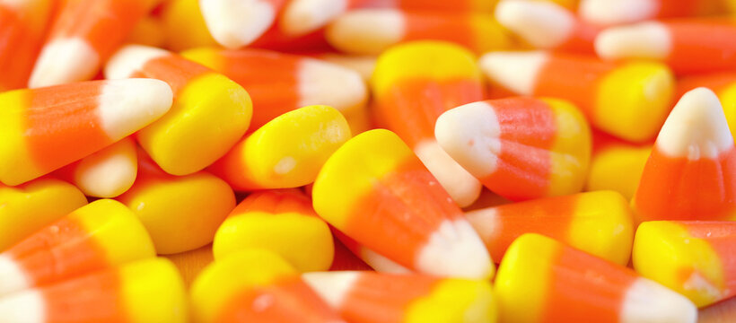 Halloween Trick or Treat Social Media Web Banner. Macro closeup of Halloween traditional Candy Corn treats background.