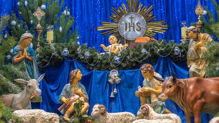 Christmas nativity scene with baby Jesus, Mary and Joseph in the manger with sheeps. Christmas event.
