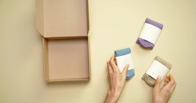 Hand Of A Woman Who Is Putting Away Socks In A Box