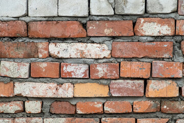 Fototapeta premium Red brick wall, real wall of an old brick house, close-up