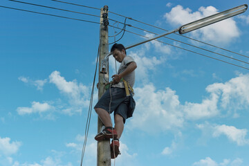 Electrician, repairman are climbing and work on electric pole. Concept of working wrong way and no...