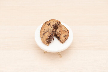 freshly baked cookie of melted dark chocolate and salted caramel on light wooden table