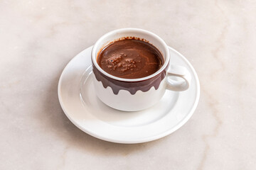 Cup of hot milk chocolate typical accompaniment to some churros