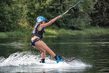 Wakeboarding on the sea on summer day in life jacket. Soft focus. Action blur.