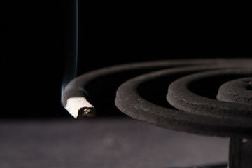 mosquito repellent coil emit smoke to repel mosquito on black background