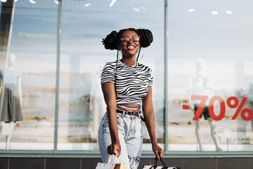 stylish african american woman, after shopping near the store, shopping on black friday
