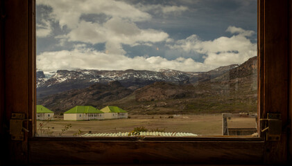 Houses in the middle of the mountains seen through the window