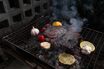 Vegetables and meat on the grill on hot coals with smoke