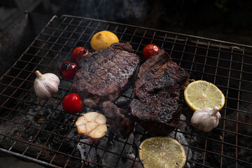 Vegetables and meat on the grill on hot coals with smoke