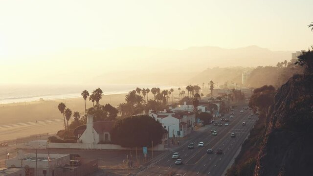View of the Pacific Coast Highway off Santa Monica Beach in Los Angeles with light traffic at beautiful golden hour, sunset atmosphere, wide angle shot. Los Angeles Califirnia USA.