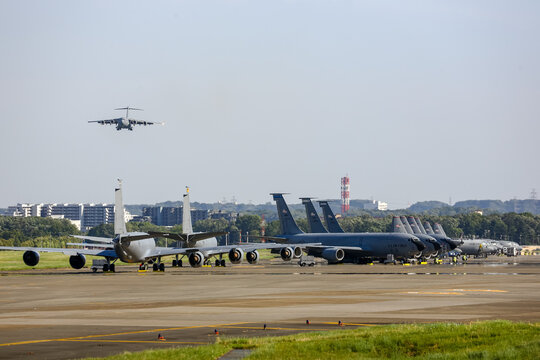 TOKYO, JAPAN: Jun 2,2017 - C-17A Globe Master landing  on the runway at Yokota Air Base, where many military aircraft are parked