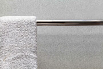 Clean white towels hang on stainless steel rails in the bathroom
