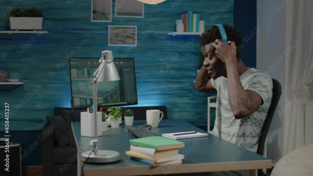 Poster engineer with headphones creating building model on computer. architect working with software to des
