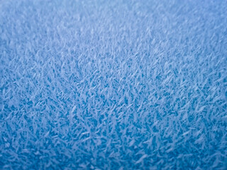 Winter ice frost on the blue table as background, soft focus