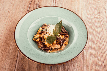 italian pasta with meat sauce in a plate on a wooden background top view