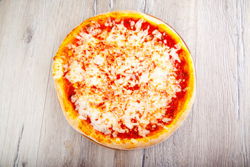 pizza margarita on wooden background top view